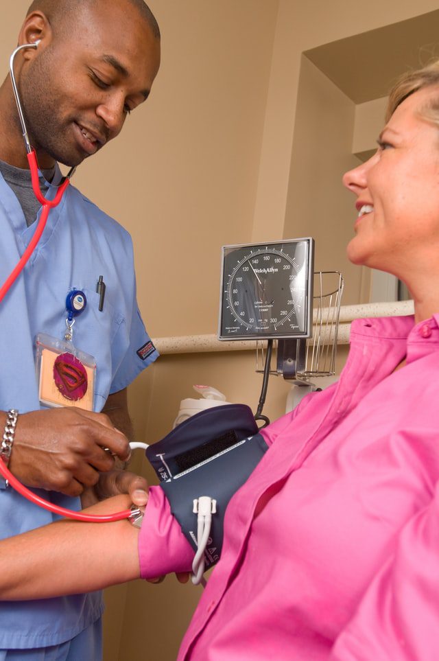 African American Doctor Taking A Woman's Pulse